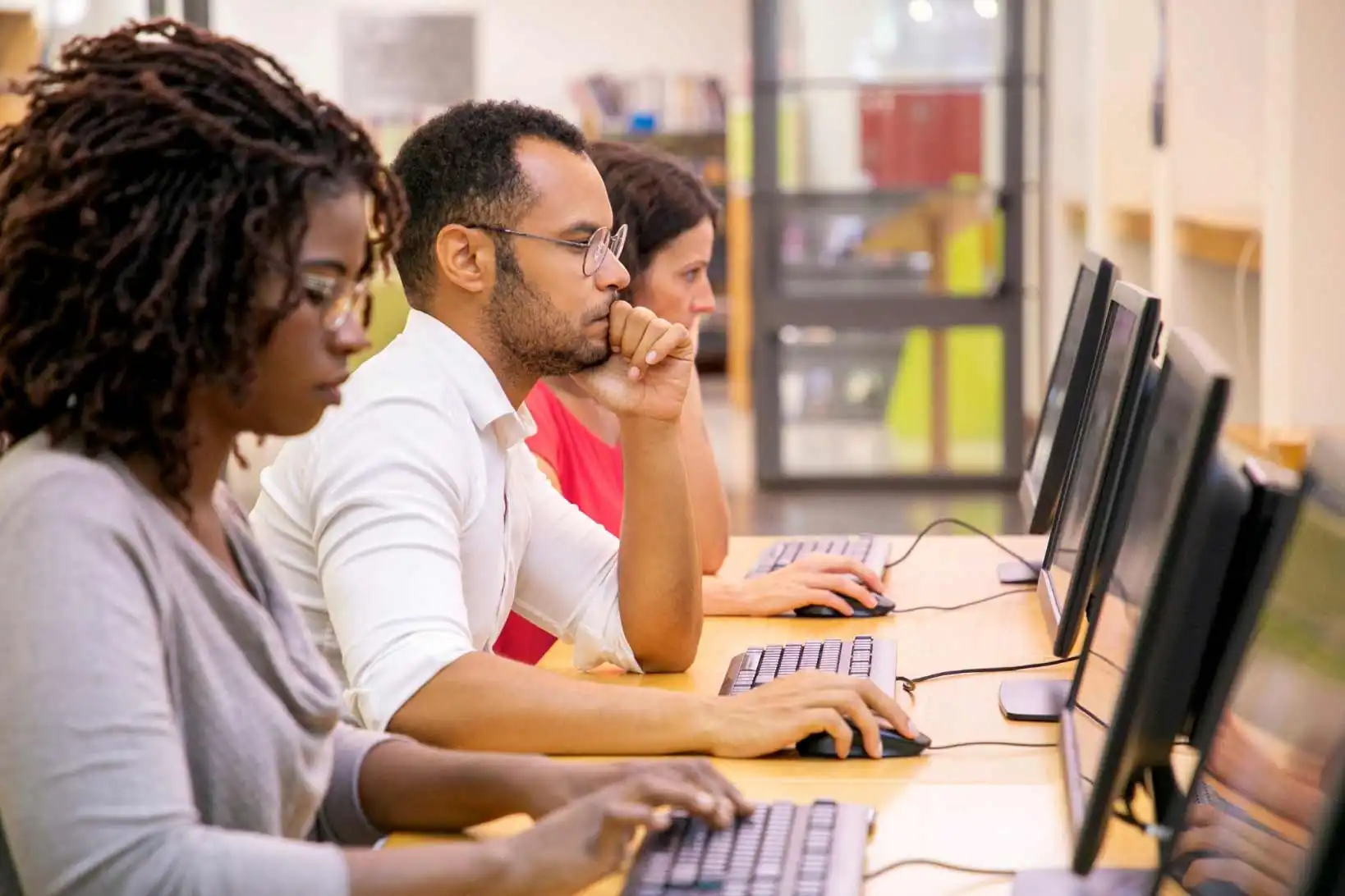 3 college students take exam at computers