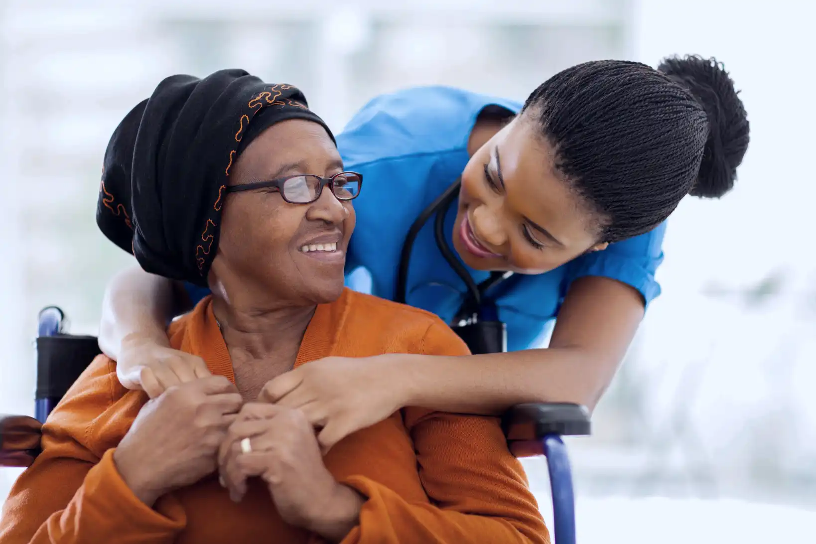 Nurse giving patient care to senior patient.