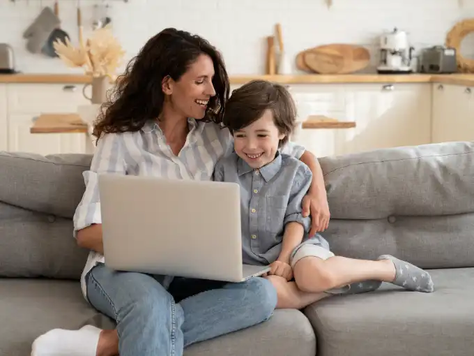 Mom earning college credit by exam with son beside her.